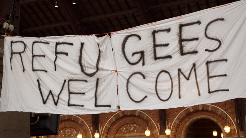 Handmade Banner Refugees Welcome Handmade banner Refugees Welcome is hanged in Copenhagen railroad station by the place where locals bring clothes for refugees.